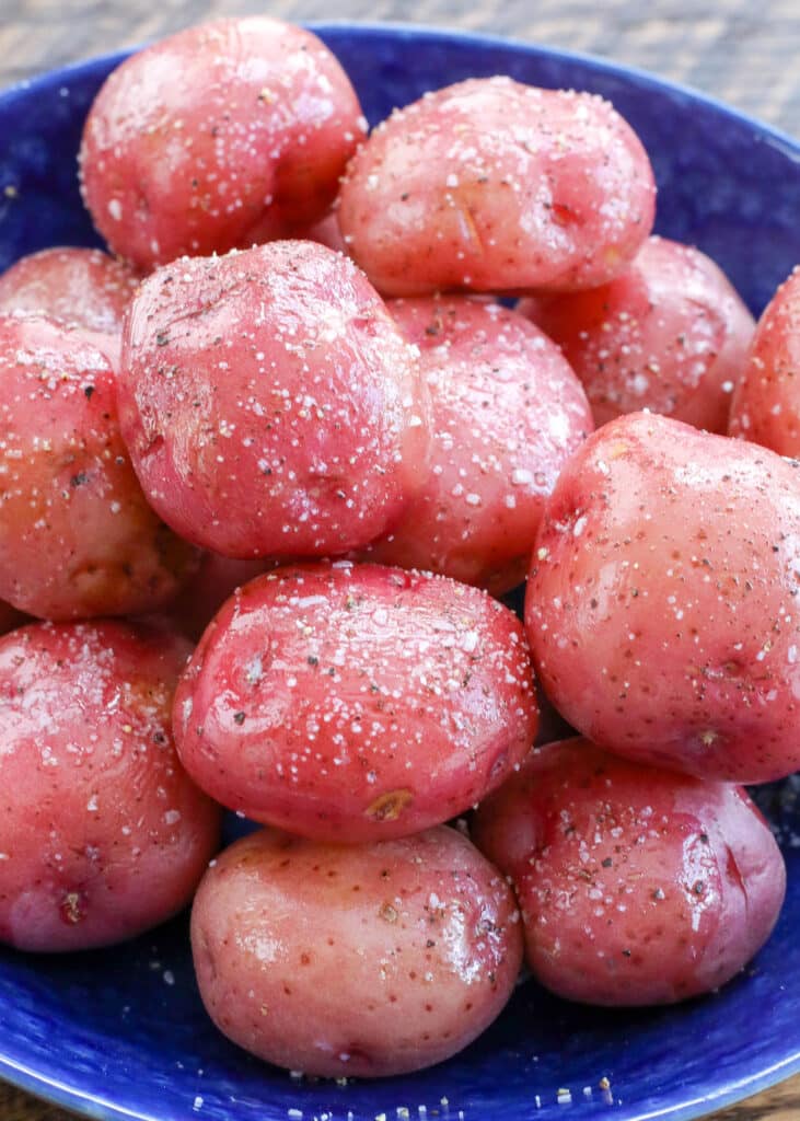 Le patate rosse lessate vengono leggermente condite con burro e cosparse di sale.