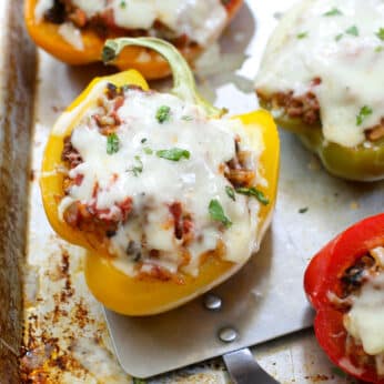 stuffed peppers on baking sheet with red and white towel