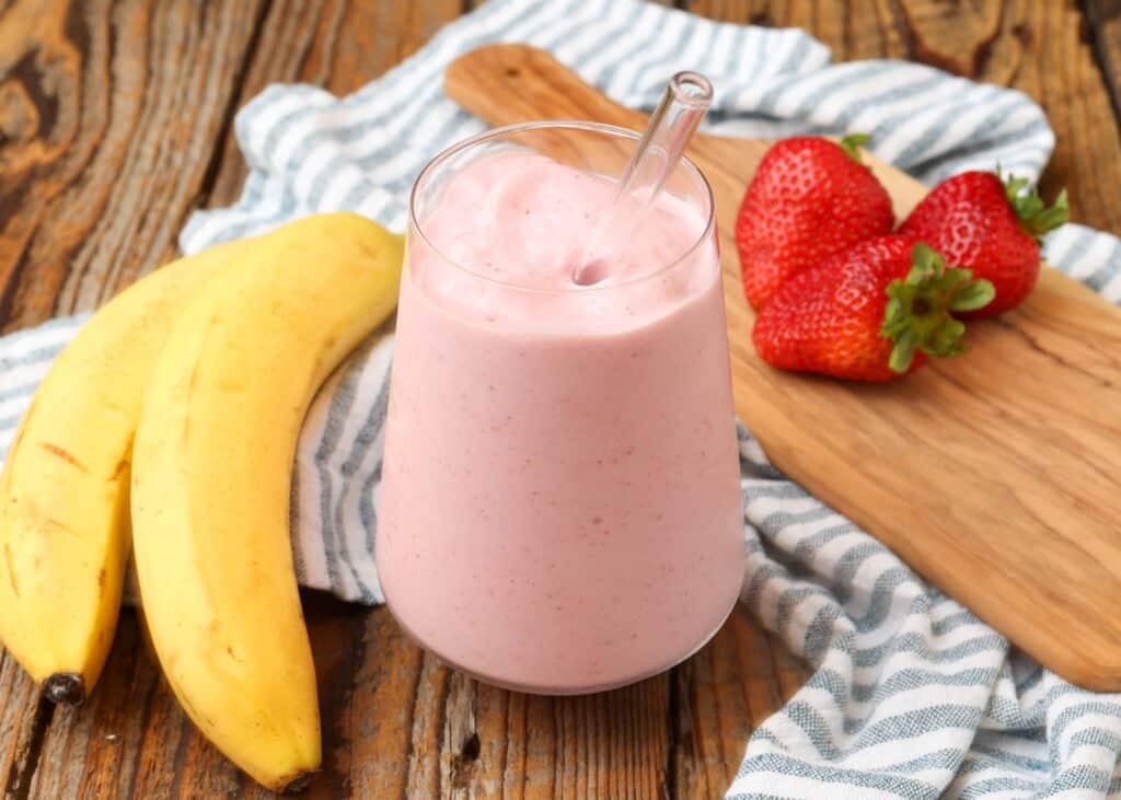 Strawberry Banana Smoothie in clear glass with fruit