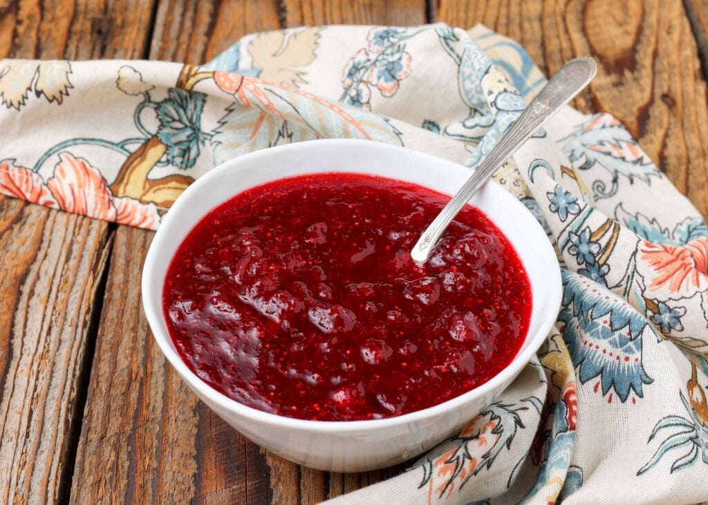 Homemade cranberry sauce in white bowl with ladle