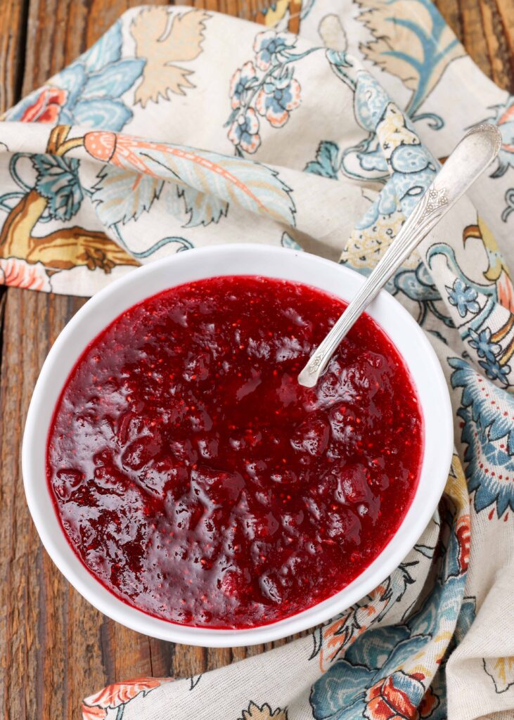 Homemade Cranberry Sauce on wooden table with floral napkin