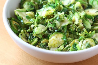 A bowl of food with broccoli, with Brussels sprout