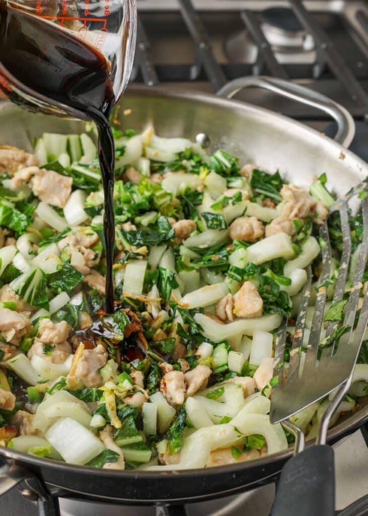 Chicken Bok Choy Stir Fry pouring in sauce