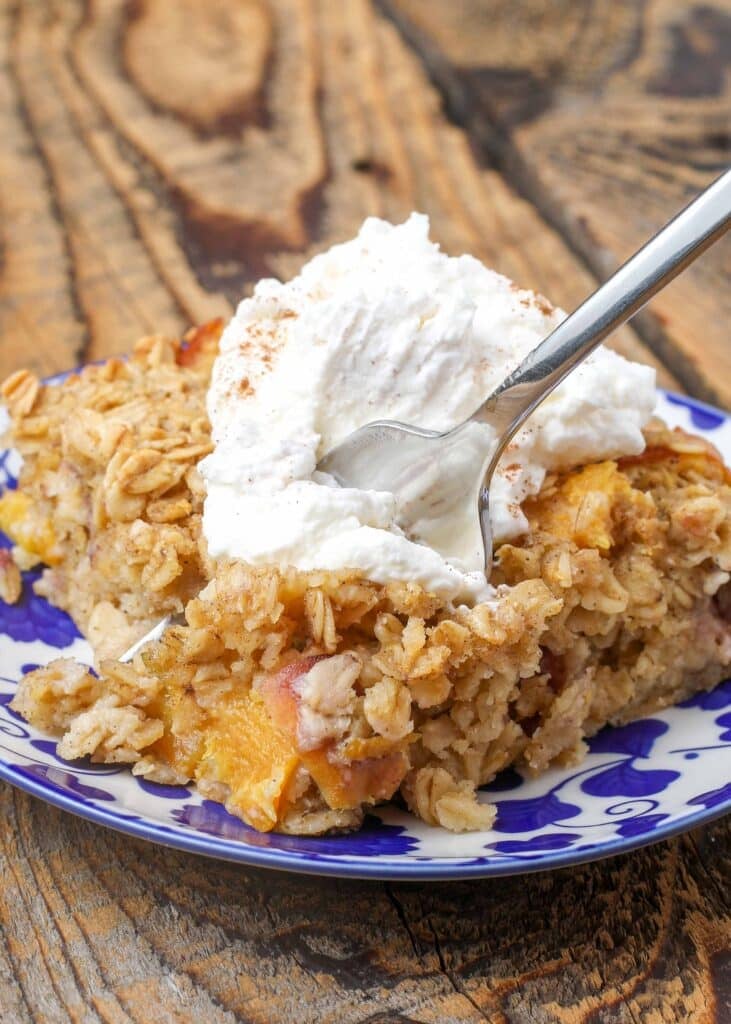 Baked Oatmeal with whipped cream on plate with fork