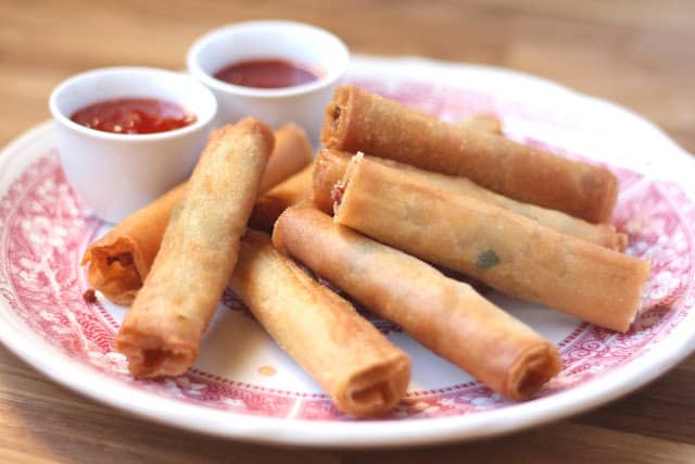A plate of hot dogs and a cup of coffee, with Lumpia and Dipping sauce