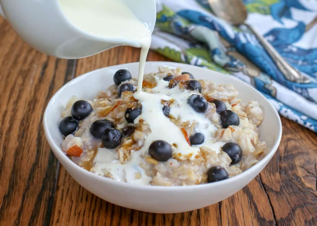 Warm, creamy oatmeal with bursting blueberries is a hearty breakfast! get the recipe at barefeetinthekitchen.com