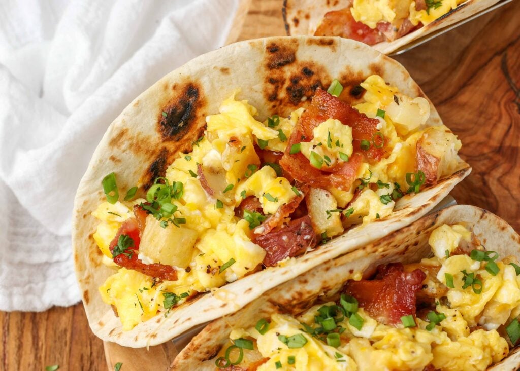 Breakfast Tacos on wooden board with white cloth