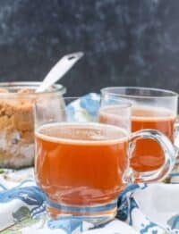 Non Alcoholic Hot Buttered Rum in clear mugs with blue linen