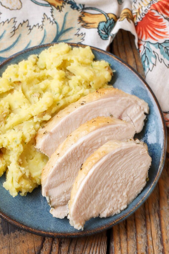 sliced turkey on plate with mashed potatoes