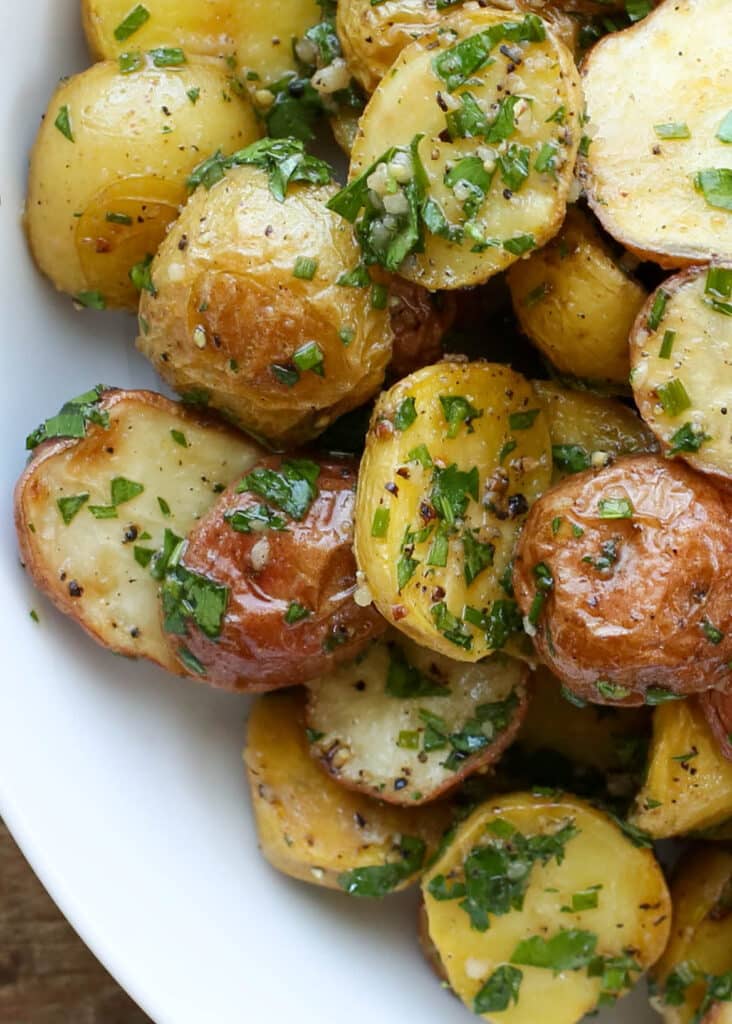 This garlic-loving potato salad that can be enjoyed hot or cold is a big hit! - Get the recipe at barefeetinthekitchen.com