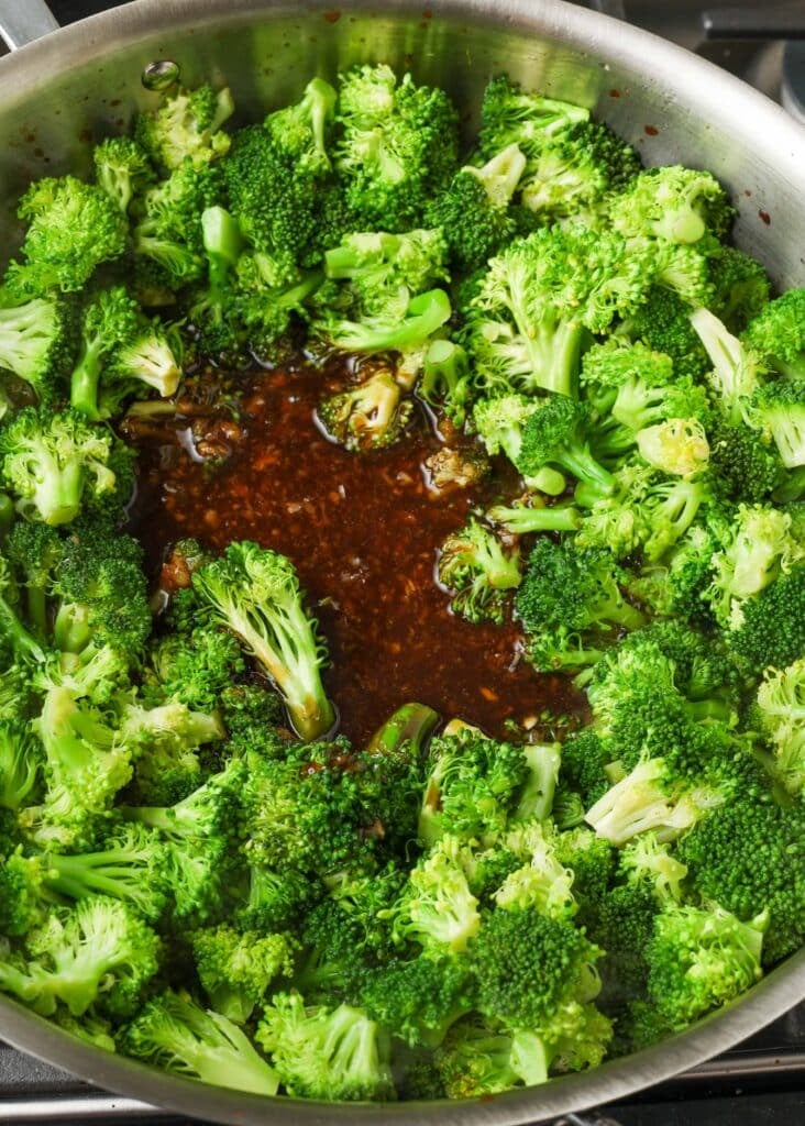 stir fry sauce poured into pan with broccoli