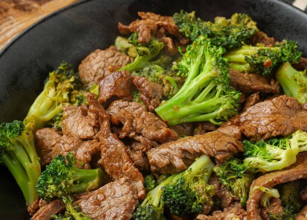 stir fry steak and broccoli in black bowl