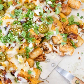 Pulled Pork Tater Tot Nachos start with piping hot cheesy tater tots that are piled high with crispy pulled pork.