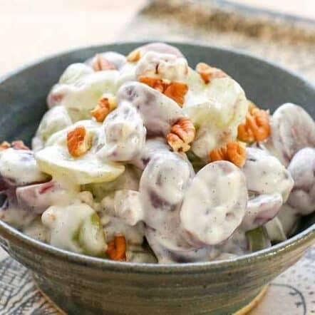 creamy fruit salad with grapes and pecans in blue pottery bowl