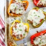 Italian style peppers stuffed with cheese and beef on tray with spatula
