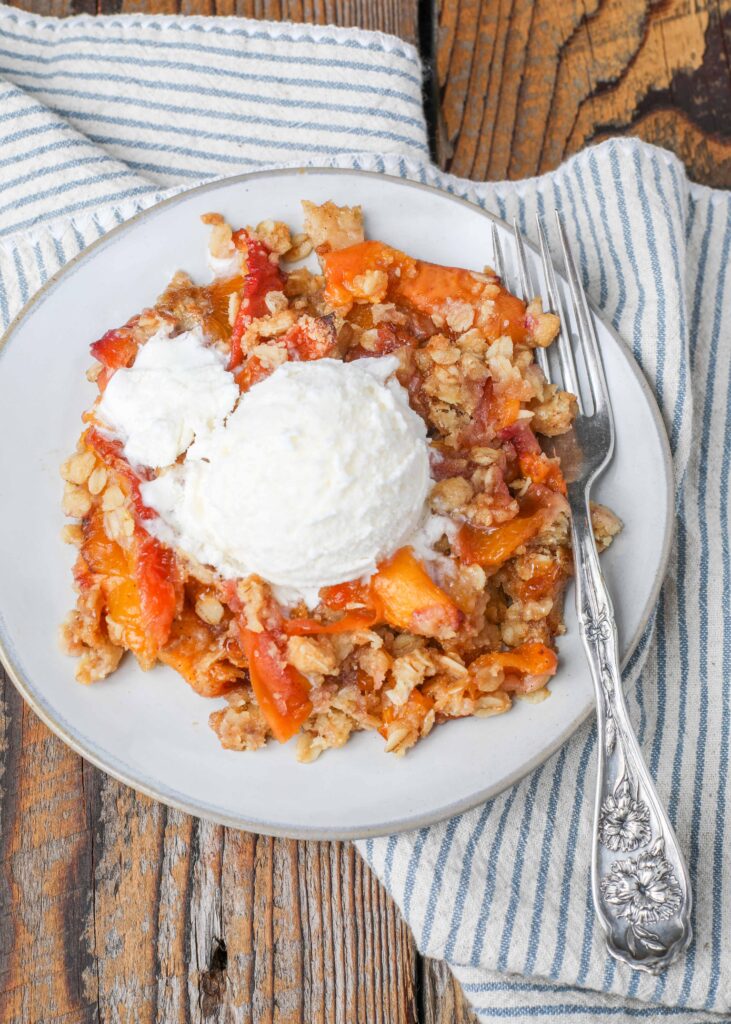 Peach cobbler with oats on plate with fork