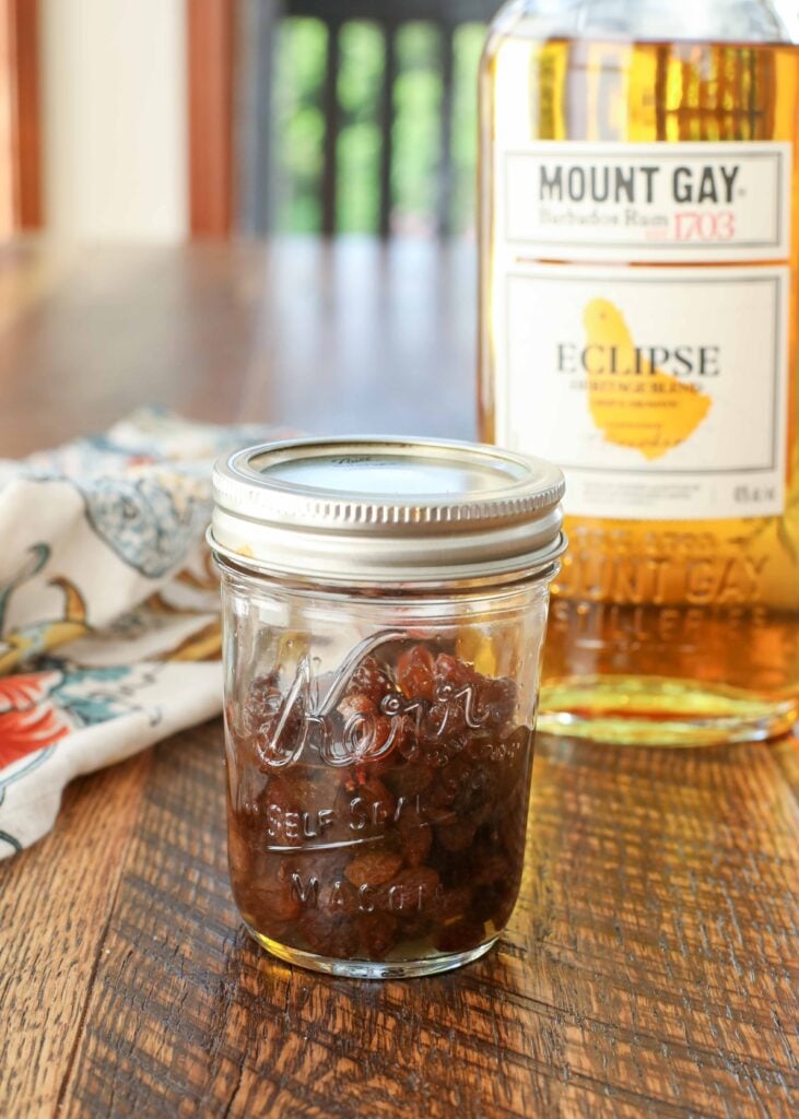 rum soaked raisins in jar next to bottle of rum