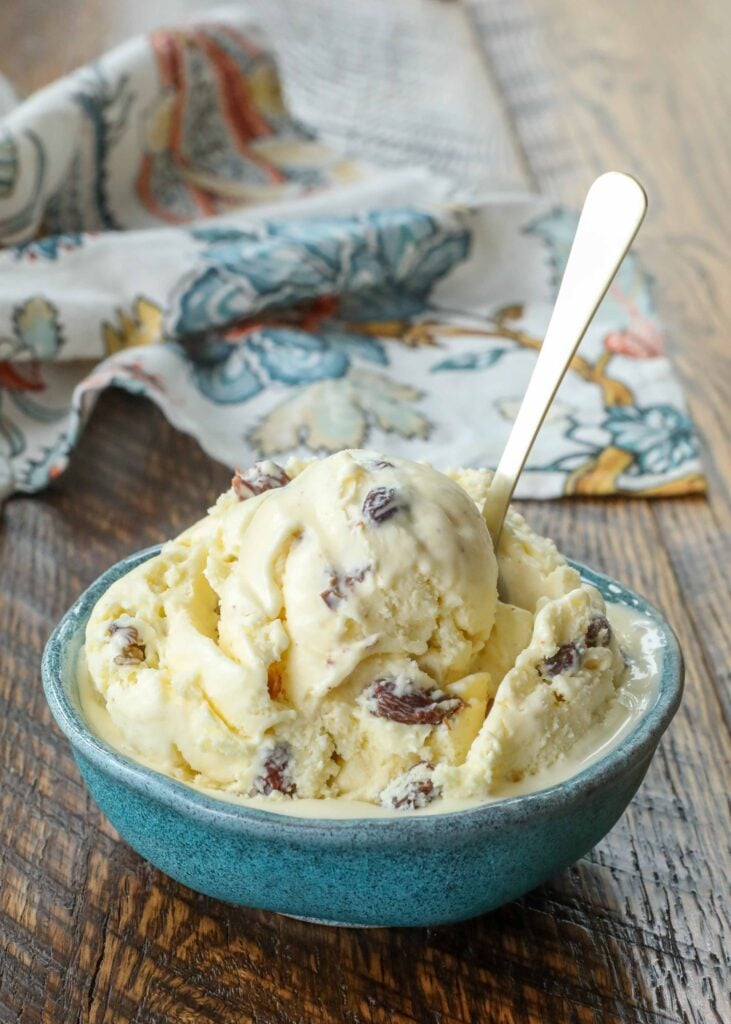 scoop of rum raisin ice cream in blue bowl with gold spoon - 6