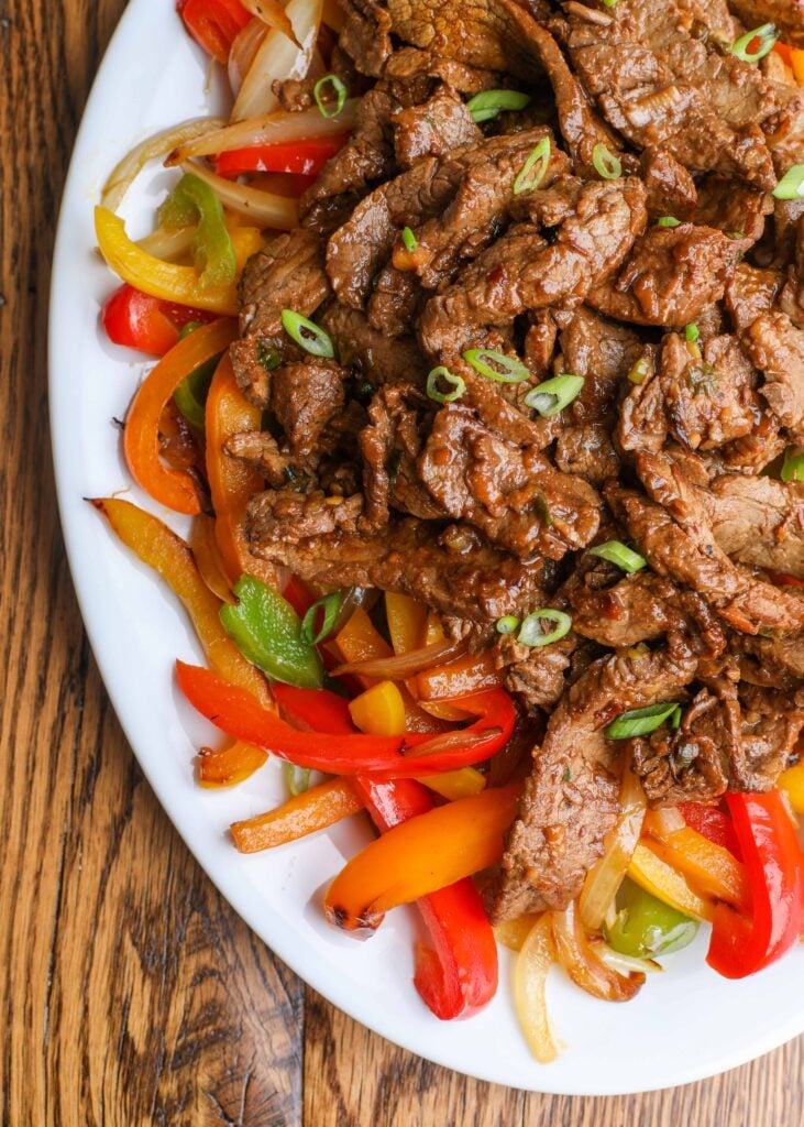 beef bulgogi on white platter with bell peppers