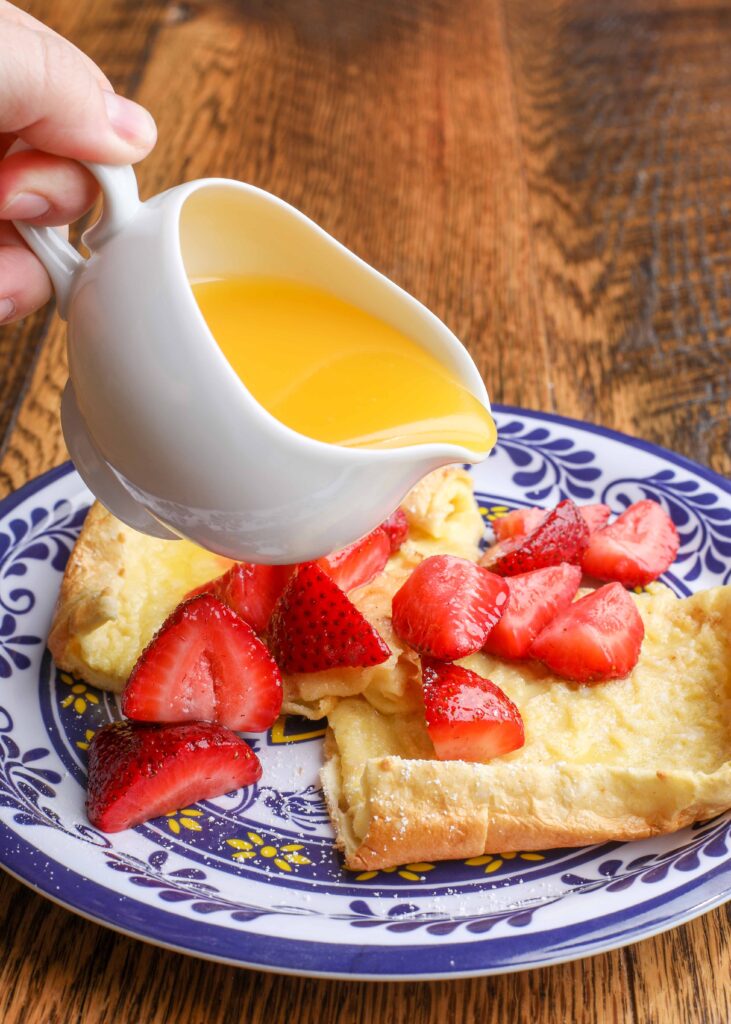 German pancakes with strawberries on undecorous plate 