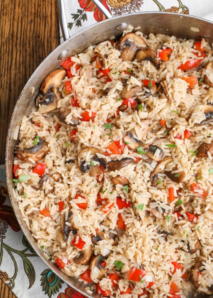 Gemüse-Reis-Pilaw mit Paprika und Pilzen in der Pfanne