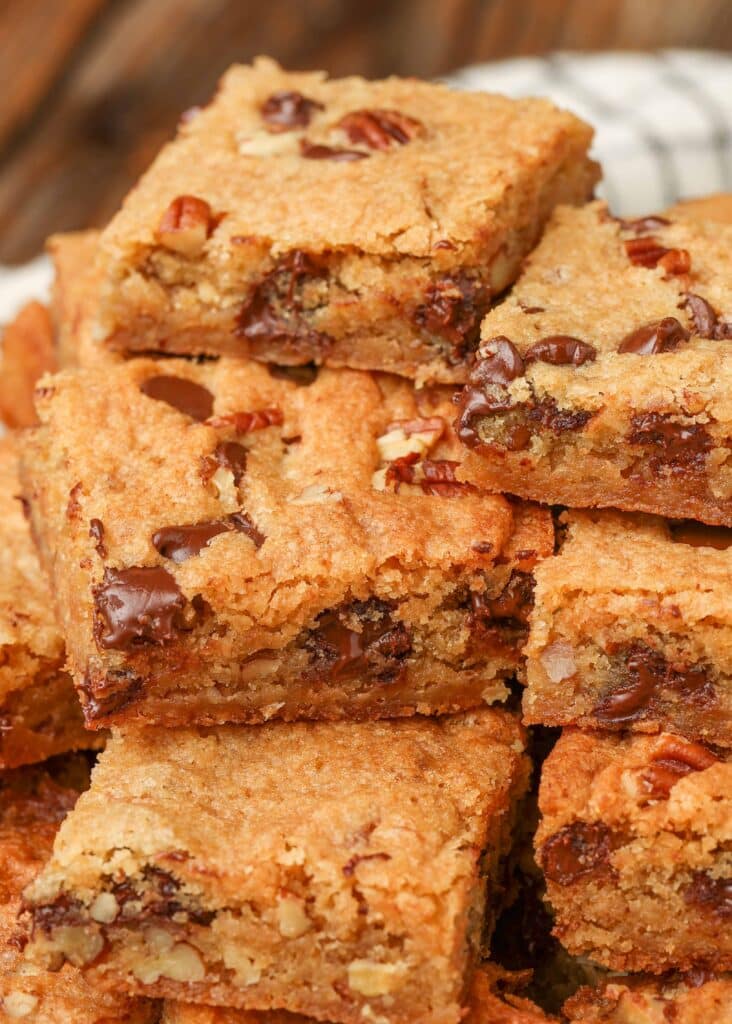 blondies with chocolate chips and pecans stacked on a plate
