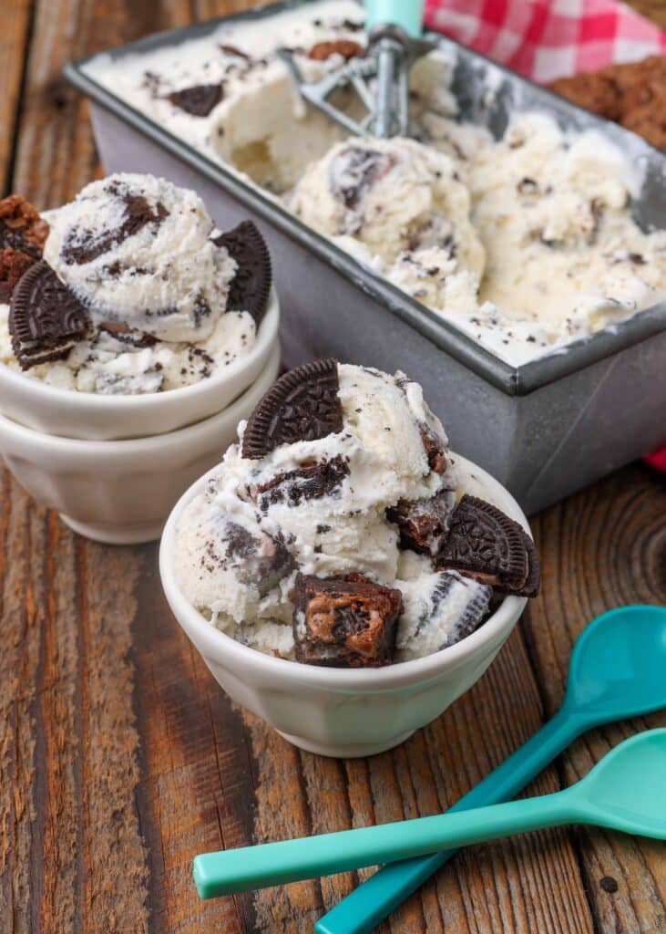 homemade ice cream with brownie pieces in pan with white bowls