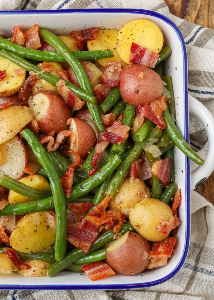 Southern green beans with potatoes and bacon in dish with tea towel