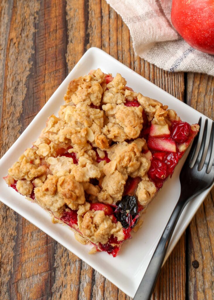 Cranberry oatmeal bars on white plate with fork