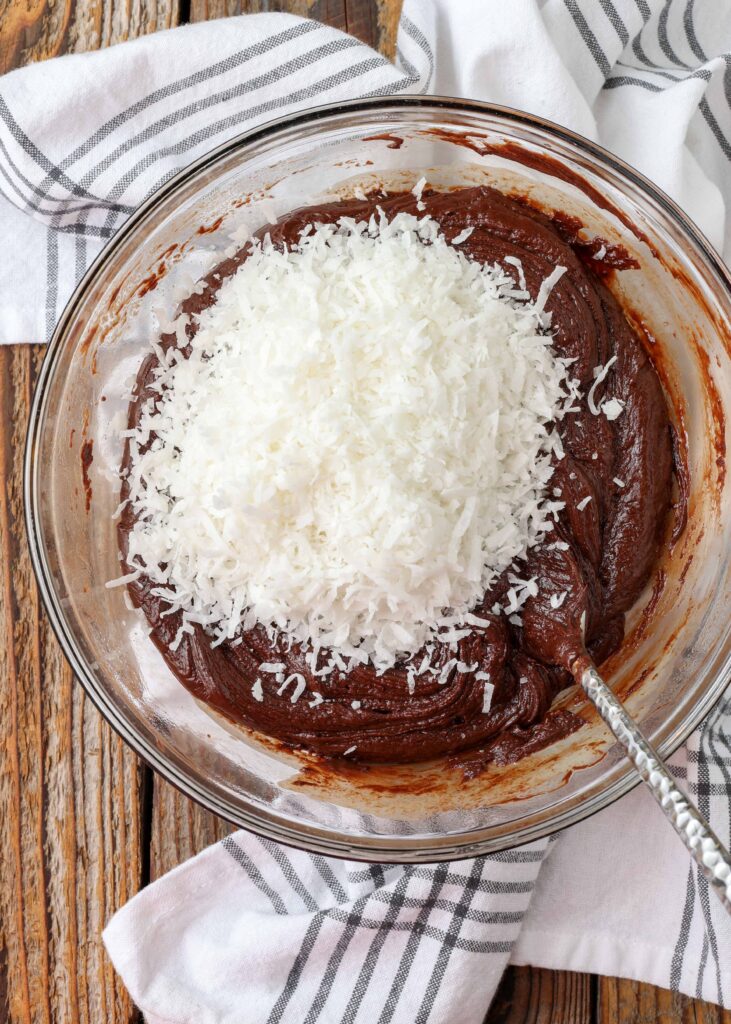 chocolate fudge batter in clear bowl with coconut