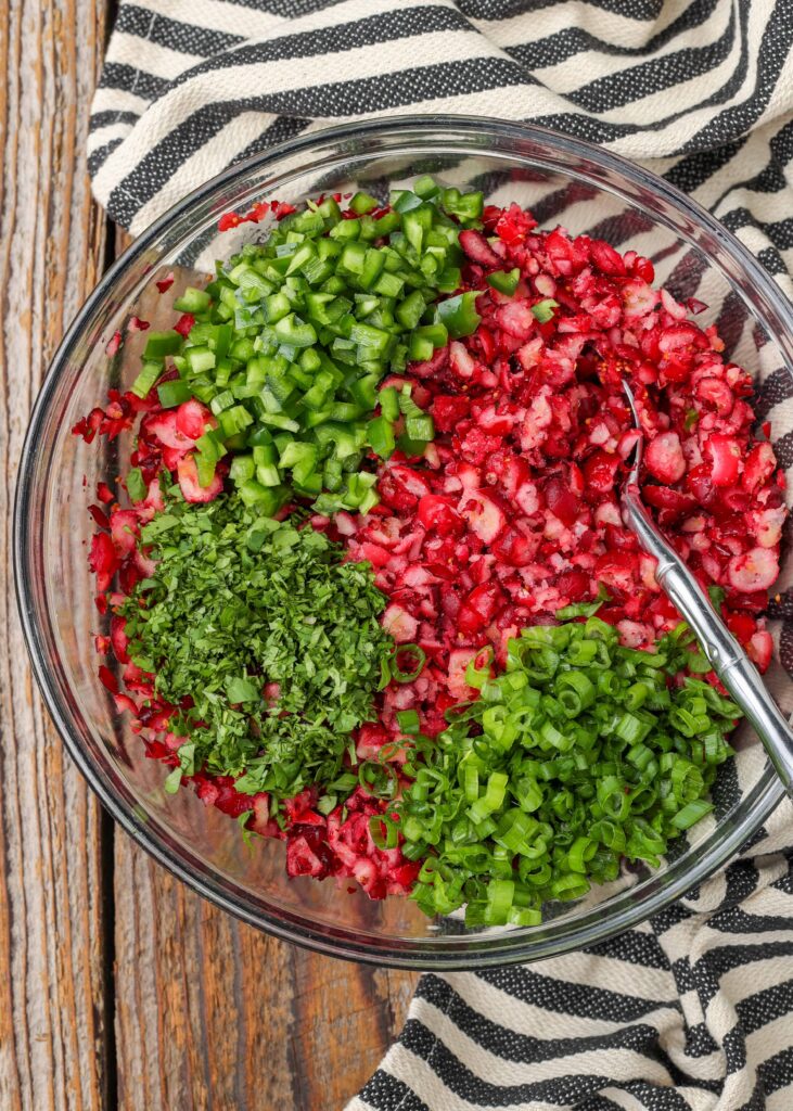 cranberries with jalapenos, cilantro, and green onions in mixing bowl