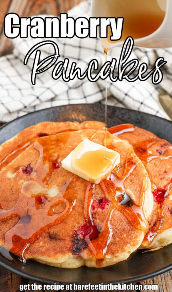 Cranberry Pancakes with syrup and butter on plate with plaid towel