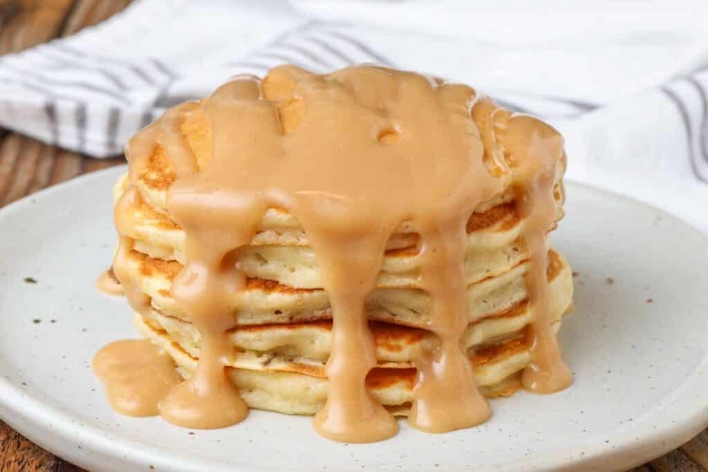 stack of pancakes topped with peanut butter sauce