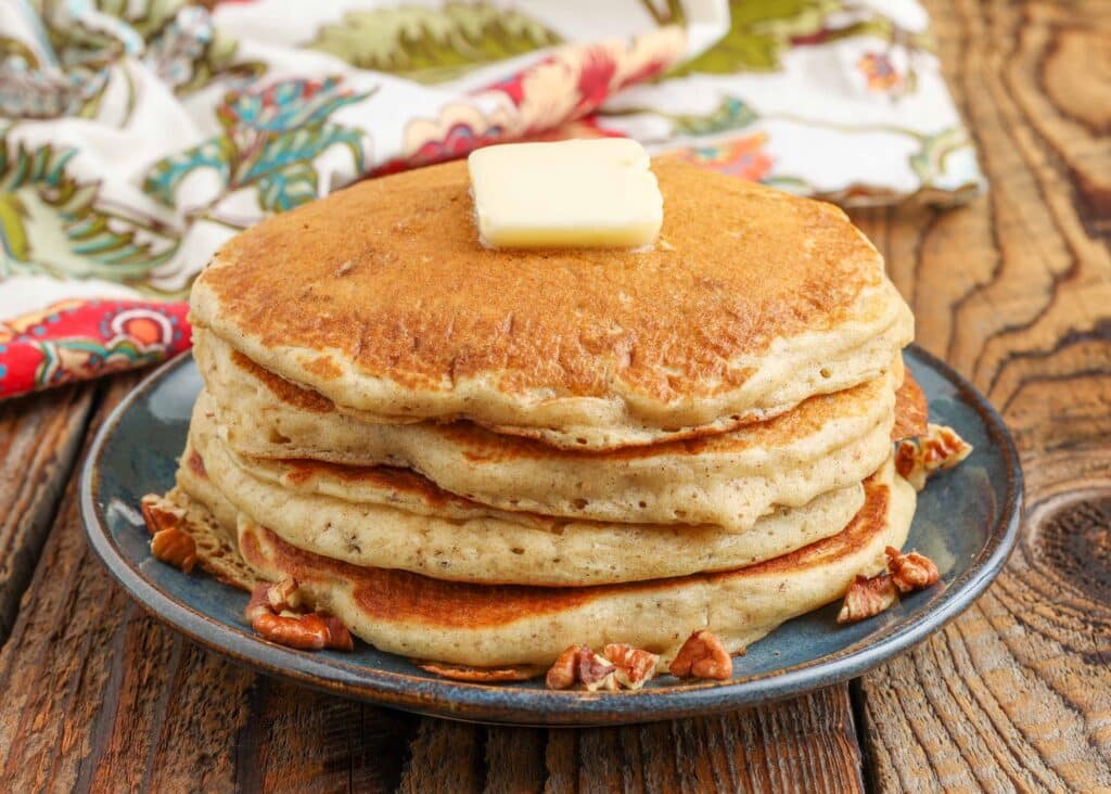 Fluffy pancakes on a blue plate with a floral towel