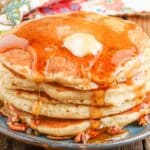 syrup over pancakes stacked on blue plate