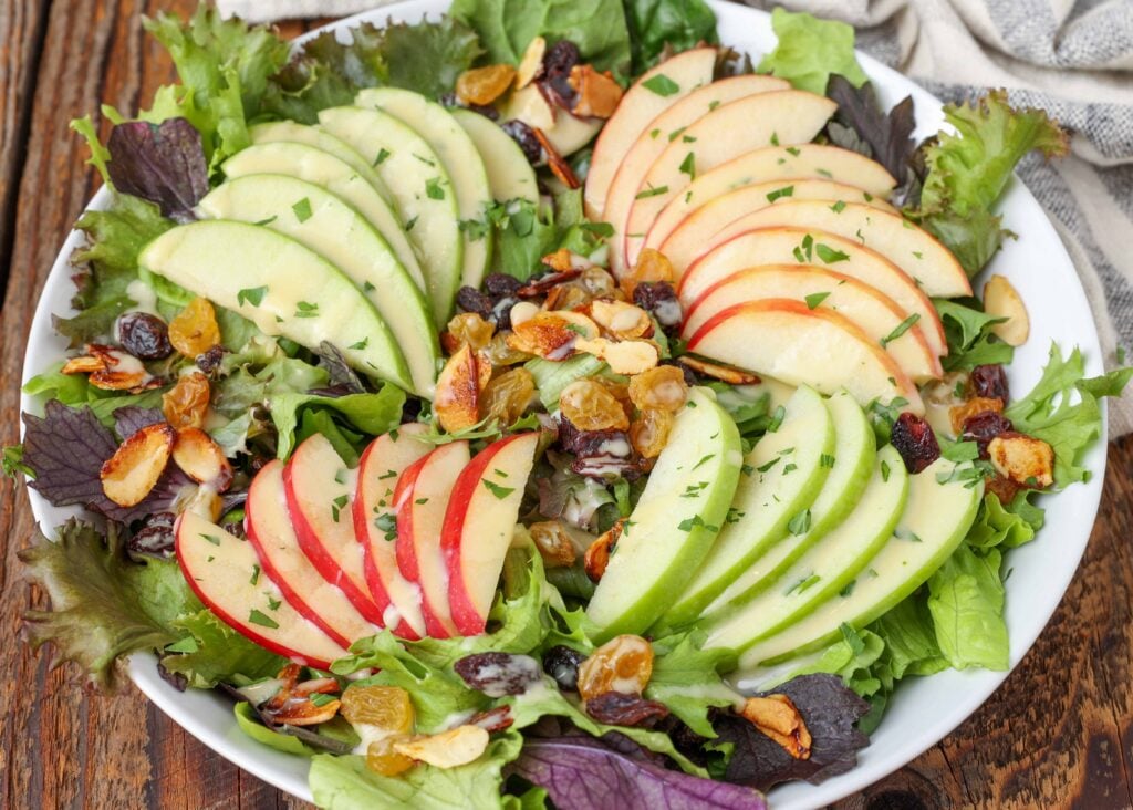 Spinach and Apple Salad in shallow white bowl with napkin