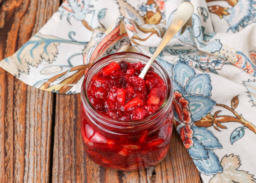 Cranberry Apple Chutney in jar with gold spoon