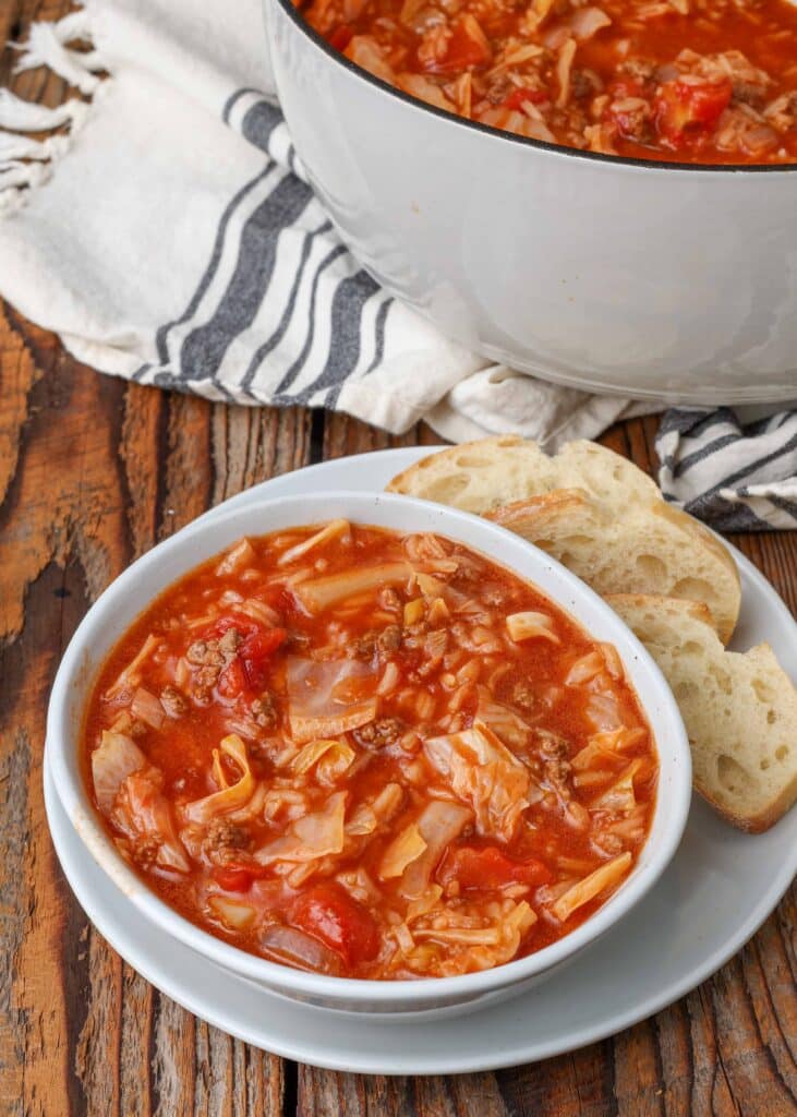 Cabbage Roll Soup in white pottery with crusty bread