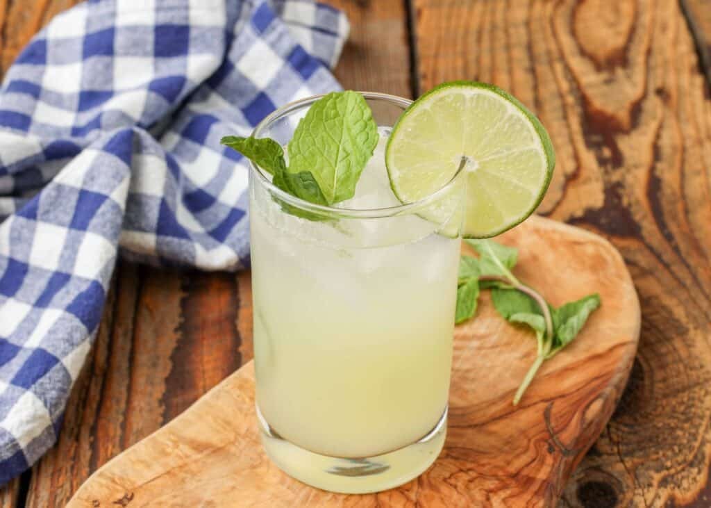 Classic mojito with mint and lime wedges in a short glass