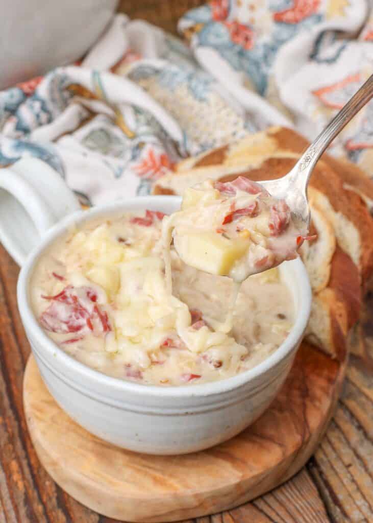 Creamy corned beef and potato soup topped with Swiss cheese