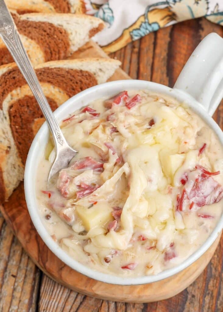 Creamy Reuben soup in a china mug and toasted rye bread