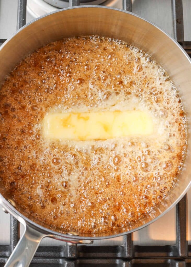la mantequilla se agrega a la salsa de caramelo en una cacerola