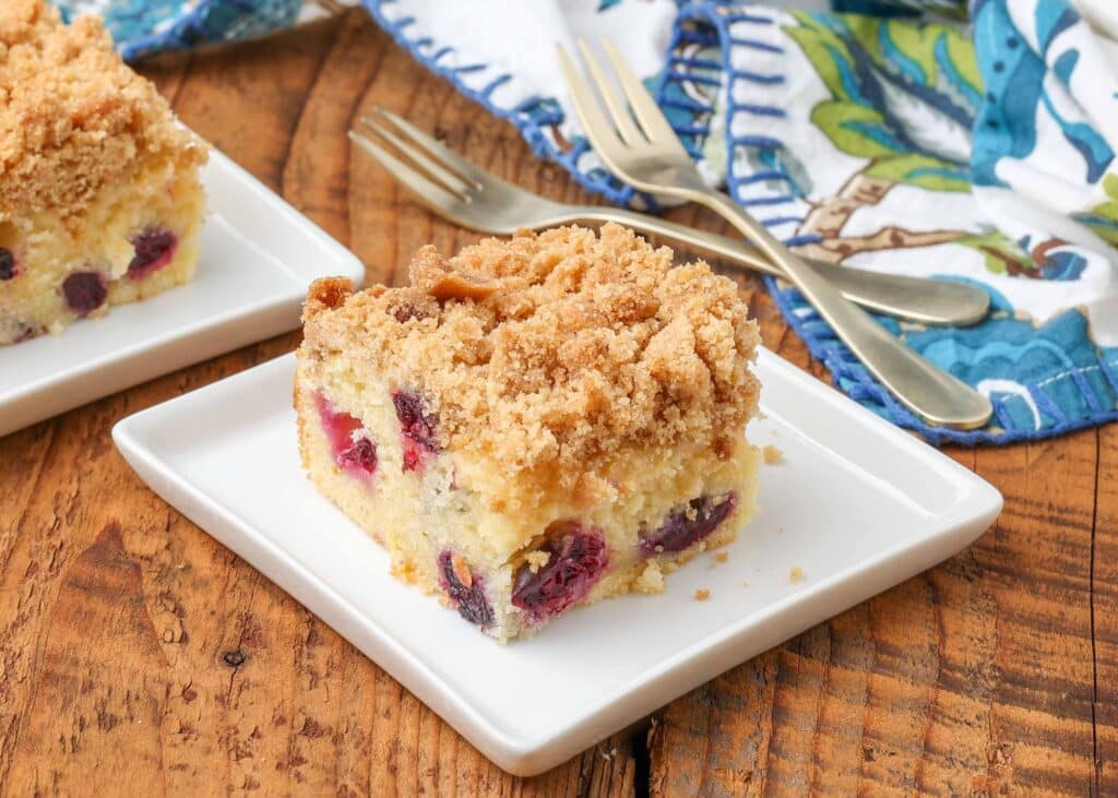 coffee cake with berries on white plate with floral napkin