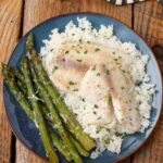 Broiled Tilapia with asparagus and rice on blue plate
