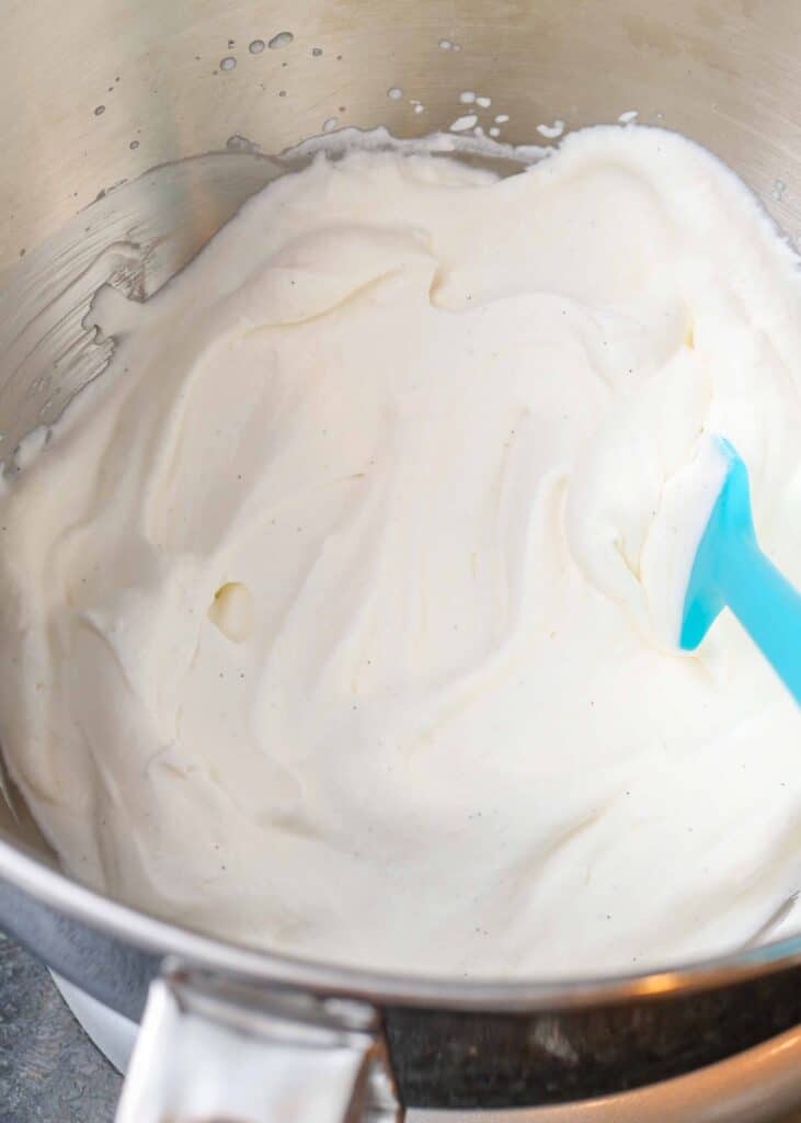 whipped vanilla cream in mixing bowl with spatula