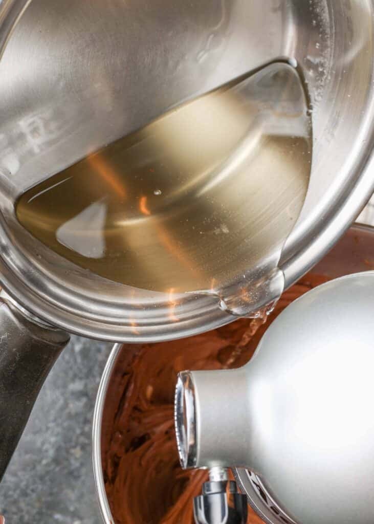 sugar water being poured into chocolate mixture