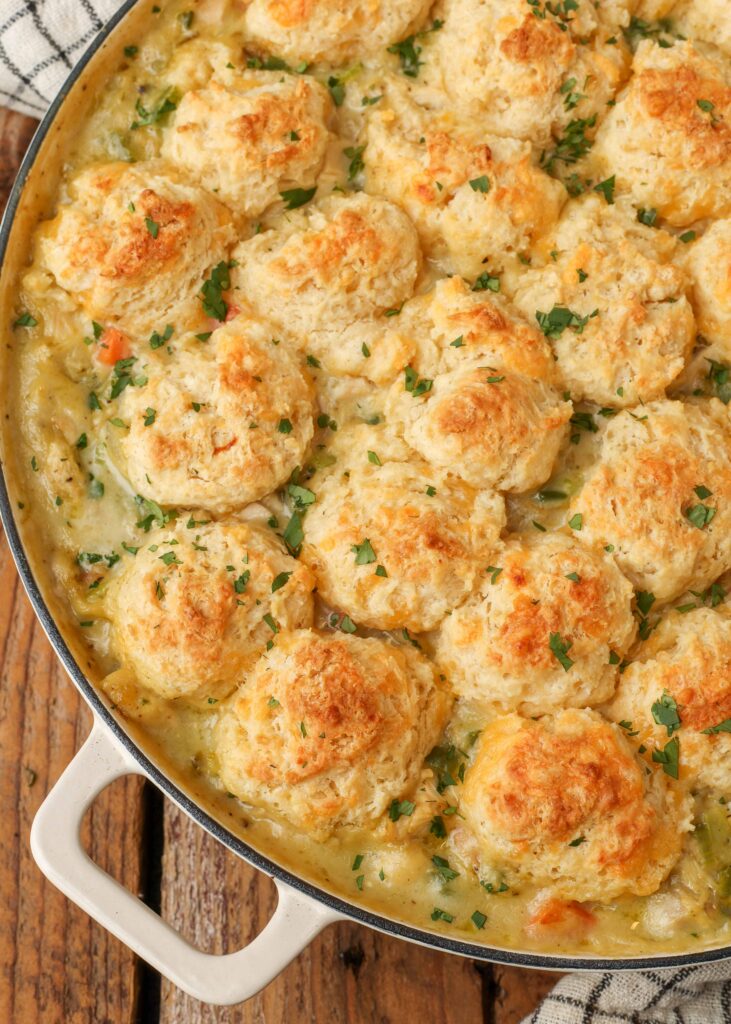 Spicy chicken pot pie topped with biscuits in a white casserole dish