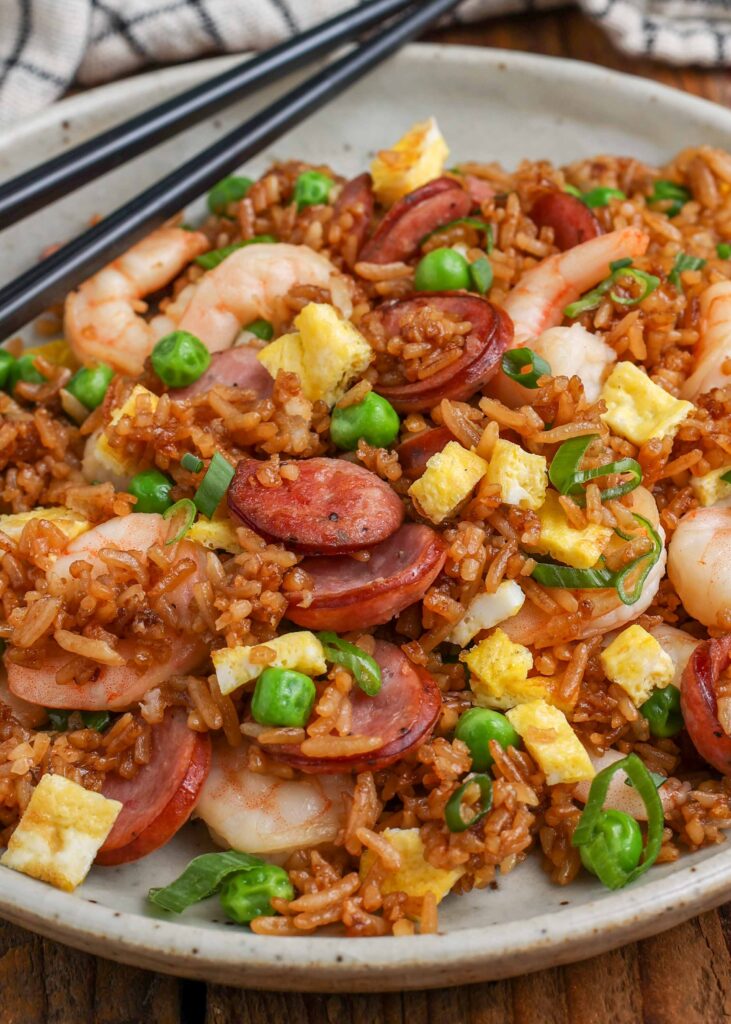 kielbasa fried rice with shrimp on plate with black chopsticks