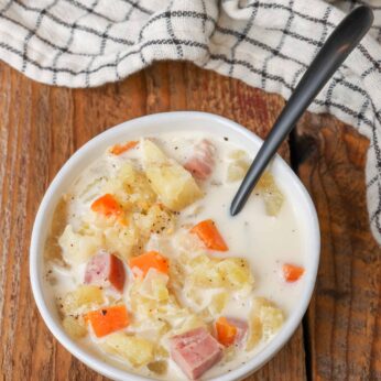 Slow Cooker Ham and Potato Soup in white bowl with spoon