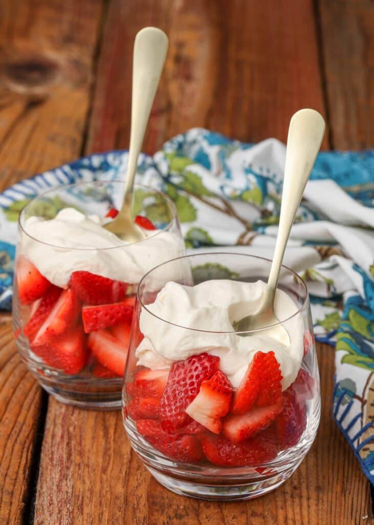strawberries in clear glasses with whipped cream sauce